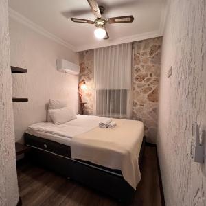 a bedroom with a bed with a ceiling fan at Villa Citronella Boutique Hotel in Antalya