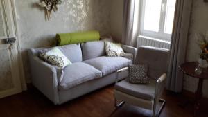 - un salon avec un canapé et une chaise dans l'établissement Le Voyageur, à Saint-Bonnet-Tronçais
