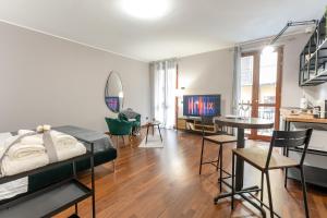 um quarto com uma cama e uma sala de estar com uma mesa em casa/studio Ricard Centro storico Arona em Arona