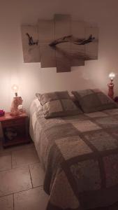 1 dormitorio con 1 cama y 2 lámparas en una mesa en gite du bois doré, en Les Vignères