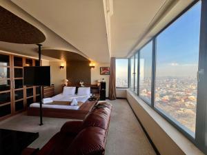 um quarto de hotel com uma cama e uma grande janela em Sky Magic view Hotel em Yerevan
