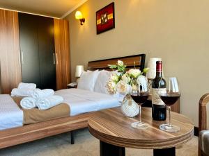 a hotel room with a bed and two tables with wine glasses at Sky Magic view Hotel in Yerevan