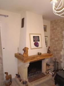 een woonkamer met een open haard en een mantel bij Chambres d'hôtes Ruoms sud Ardèche in Ruoms