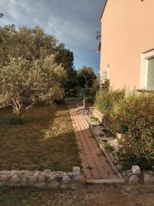 een bakstenen pad in een tuin naast een gebouw bij Chambres d'hôtes Ruoms sud Ardèche in Ruoms