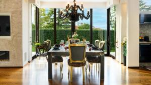 a dining room with a table with chairs and a chandelier at VILLA VAE VICTIS 6, Emma Villas in Coriano