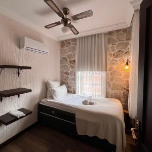 a bedroom with a bed with a ceiling fan at Villa Citronella Boutique Hotel in Antalya