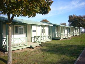 a row of green and white mobile homes at ULVF Les Beaupins in Saint-Denis-dʼOléron