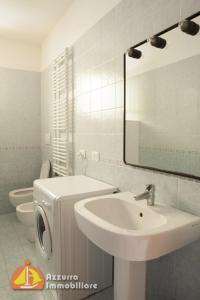 y baño con lavabo, aseo y espejo. en Residence Borgo dei Fiori H06, en Lido di Jesolo