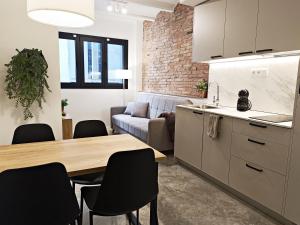 cocina y sala de estar con mesa y sillas en ARIQUS Fira Apartments en Hospitalet de Llobregat