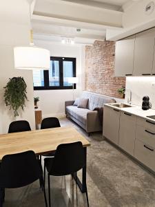 ARIQUS Fira Apartments في لوسبيتاليت دي يوبريغات: مطبخ وغرفة معيشة مع طاولة وكراسي