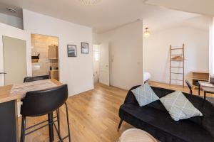 ein Wohnzimmer mit einem schwarzen Sofa und einem Tisch in der Unterkunft Coquelin - Joli appartement rénové in Rennes