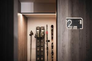 a group of skis and ski poles in a room at Timeless Dolomites Apartments in Dobbiaco