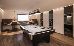 a living room with a pool table and a screen at Timeless Dolomites Apartments in Dobbiaco