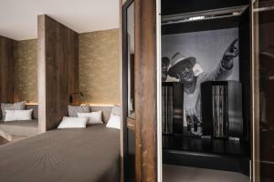 a room with a bed with a poster on the wall at Timeless Dolomites Apartments in Dobbiaco