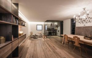 a dining room and living room with a chandelier at Timeless Dolomites Apartments in Dobbiaco