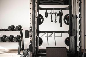 a gym with dumbbells and weights at Timeless Dolomites Apartments in Dobbiaco