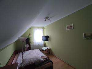 una camera da letto con pareti verdi, un letto e una finestra di Zielony Zakątek a Piechowice