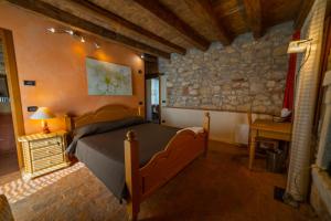 een slaapkamer met een bed en een stenen muur bij AGRITURISMO RIVA RATTA in Montecchio Maggiore