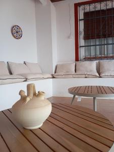 sala de estar con jarrón y mesa en Villa Romero, en Mairena del Alcor