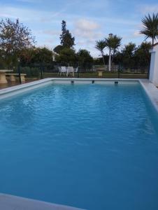 a large swimming pool with blue water at Villa Romero in Mairena del Alcor