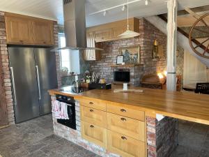 a kitchen with a wooden counter top and a refrigerator at Åkerbo gård charmigt renoverad flygel in Kristinehamn