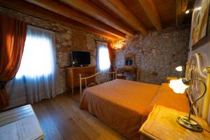 een slaapkamer met een bed en een televisie in een kamer bij AGRITURISMO RIVA RATTA in Montecchio Maggiore