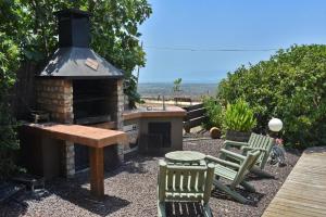 ハッド・ネスにあるאוויר ואווירה - בקתות מקסימות עם ג'קוזי פרטי ונוף ישיר לכנרתの暖炉、テーブル、椅子が備わる裏庭