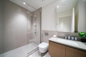 a bathroom with a shower and a toilet and a sink at Brand New 1BDR In Summer At Creek Beach in Dubai