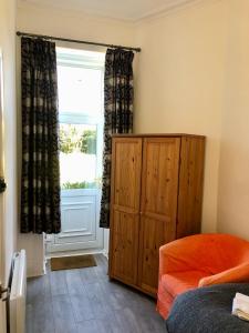a bedroom with a wooden cabinet and a window at Spare Room Stay in Edinburgh