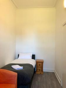 a small bedroom with a bed and a table at Spare Room Stay in Edinburgh