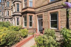 a brick house with bushes in front of it at Spare Room Stay in Edinburgh