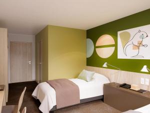ゲレにあるibis Styles Guéretの緑の壁、ベッド付きのベッドルーム1室