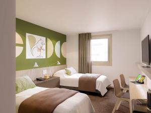 una camera d'albergo con due letti e una televisione di ibis Styles Guéret a Guéret