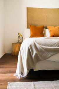 een slaapkamer met een bed met oranje kussens bij La Posada de Trafalgar in Los Caños de Meca