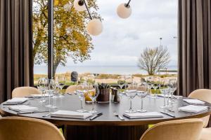 - une table avec des verres à vin devant une fenêtre dans l'établissement Hotel Skansen Båstad, à Båstad