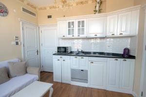 uma cozinha branca com armários brancos e um sofá em IQ Hotel Galatasaray em Istambul