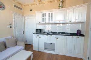 a white kitchen with white cabinets and a couch at IQ Hotel Galatasaray in Istanbul