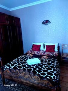 una camera da letto con un letto bianco e nero con cuscini rossi di guest house lela rezo a Kazbegi