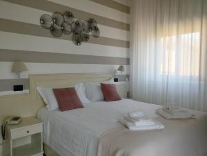 Un dormitorio con una cama blanca con toallas. en Hotel La Fontana en Stresa