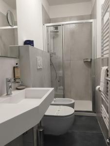 La salle de bains est pourvue d'un lavabo, de toilettes et d'une douche. dans l'établissement Hotel La Fontana, à Stresa