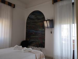 a bedroom with a bed and a painting on the wall at Hotel La Fontana in Stresa
