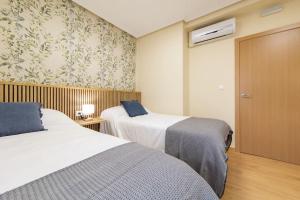 una habitación de hotel con 2 camas y una puerta en Exclusive & cozy apartment in the center of Soria, en Soria