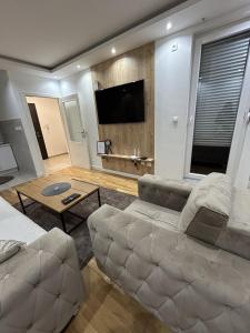 a living room with a couch and a flat screen tv at Apartment Sun & Moon in Sarajevo +4 photos
