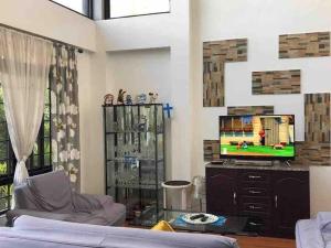 a living room with a couch and a tv at Casa Erlinda, modern newly built house 3BR for 8! in Tigaon