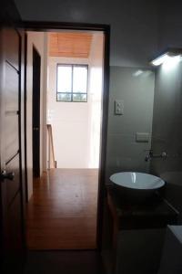 a bathroom with a sink and a door with a window at Casa Erlinda, modern newly built house 3BR for 8! in Tigaon