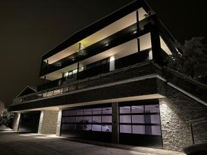 a building lit up at night with a car on it at Timeless Dolomites Apartments in Dobbiaco