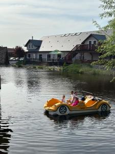 un groupe de personnes à bord d'un bateau en caoutchouc dans une rivière dans l'établissement Hotel Nenufar, à Kościan