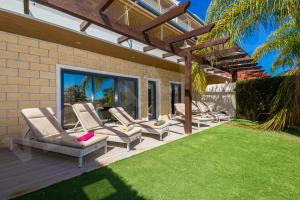 ラゴスにあるCasa Vista da Lagosのラウンジチェアと芝生のあるパティオ