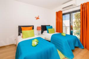 a bedroom with two beds with colorful pillows at Casa Vista da Lagos in Lagos