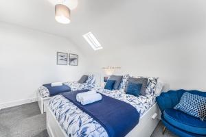 ein Schlafzimmer mit einem Bett und einem blauen Stuhl in der Unterkunft Luxury Stay - Parking, Close City Centre, Netflix & Disney, in Nottingham